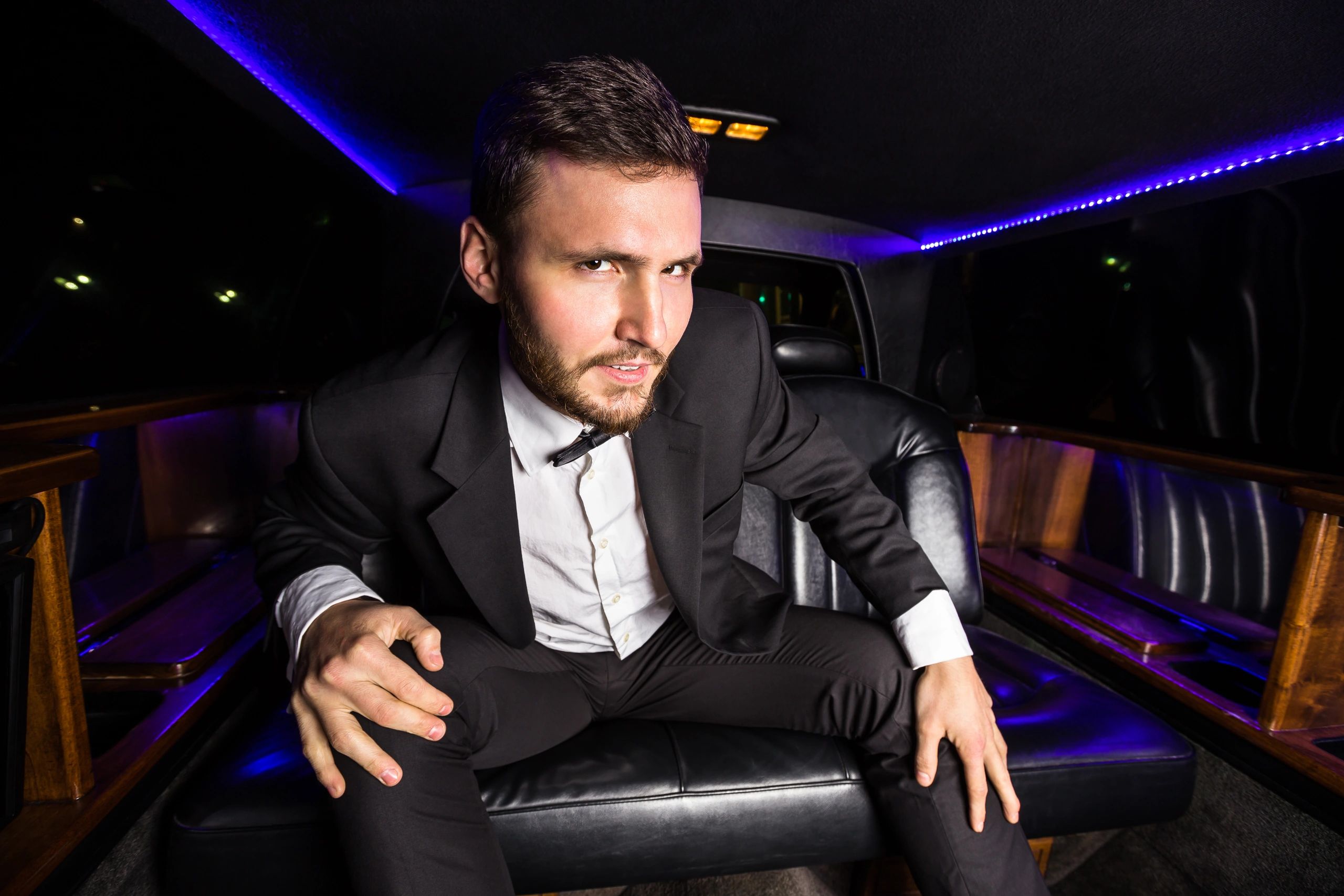 Man in formalwear inside a limousine